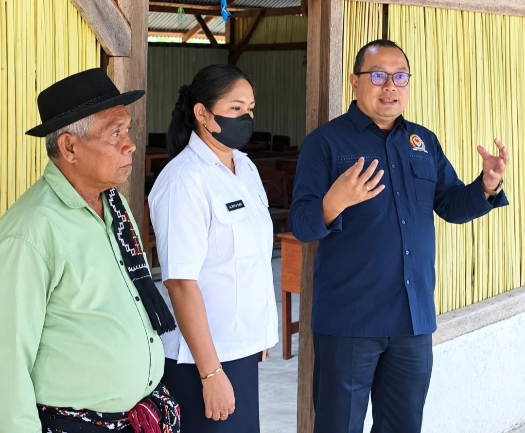 Gambar kunjungan di SMAN 2 Sulamu yang dimuat Kupang Media; tampak dinding sekolah dan sejumlah orang dewasa.